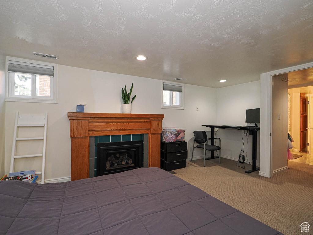 Carpeted bedroom featuring a fireplace and recessed lighting