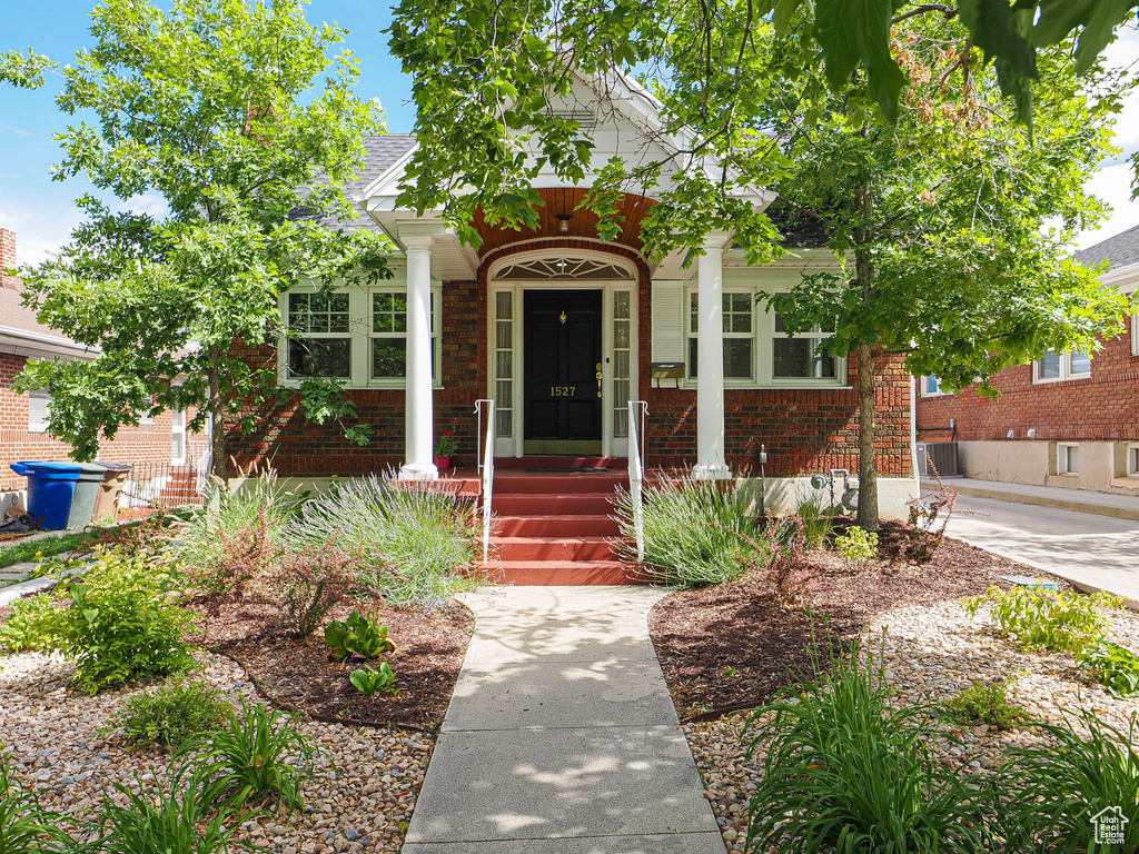 View of front of house with brick siding and covered porch