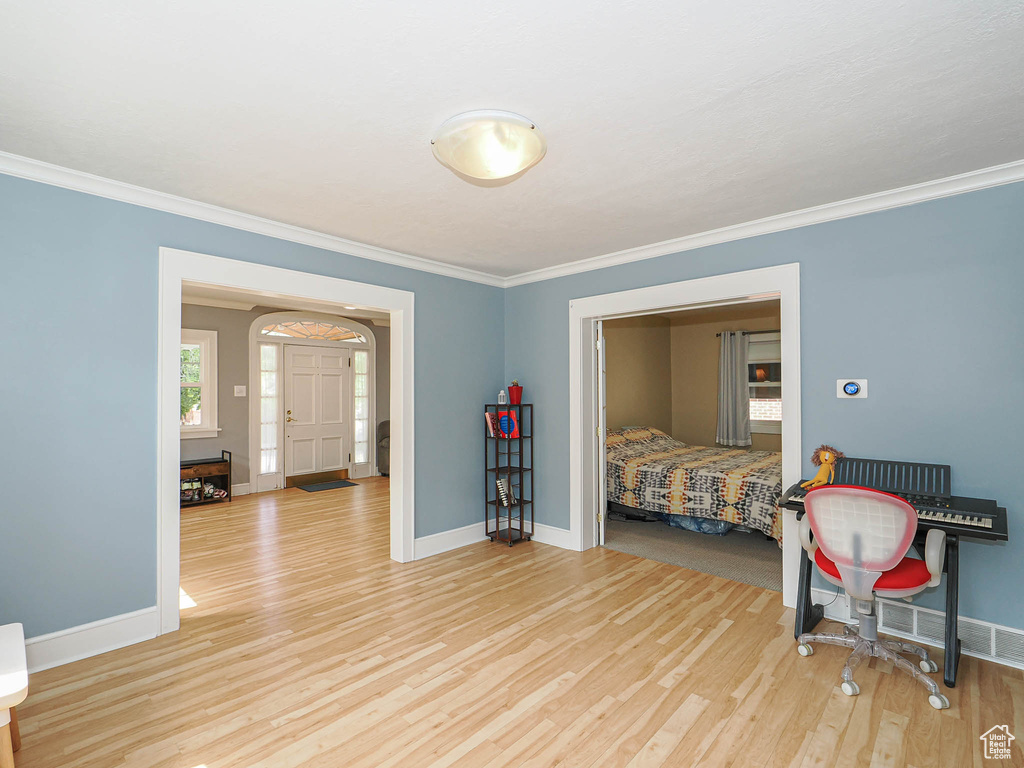 Bedroom with light wood-type flooring and ornamental molding