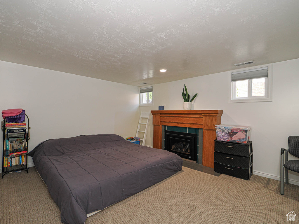 Carpeted bedroom featuring a fireplace and baseboards