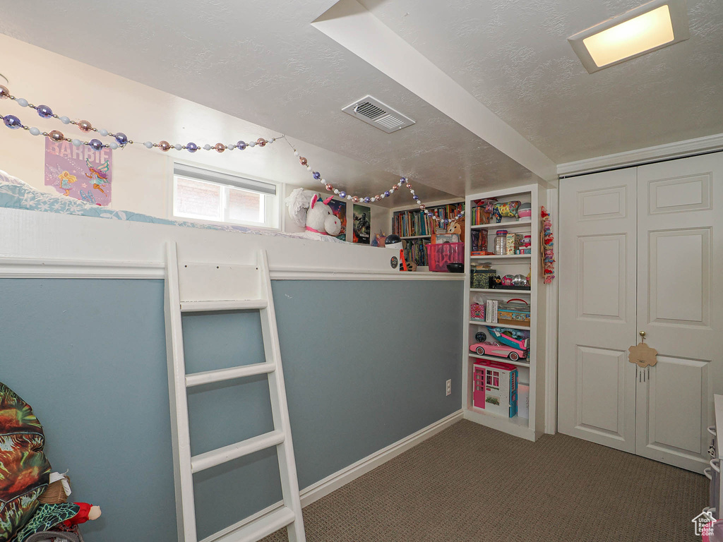Bedroom featuring a textured ceiling, carpet flooring, and a closet