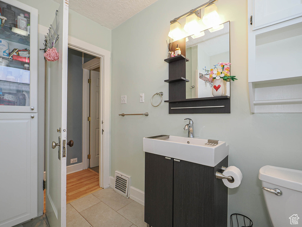 Half bath featuring vanity, tile patterned flooring, and a textured ceiling