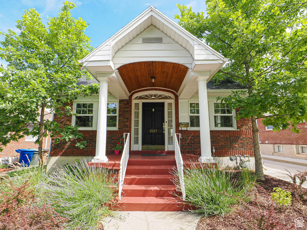 View of front facade featuring brick siding and a porch