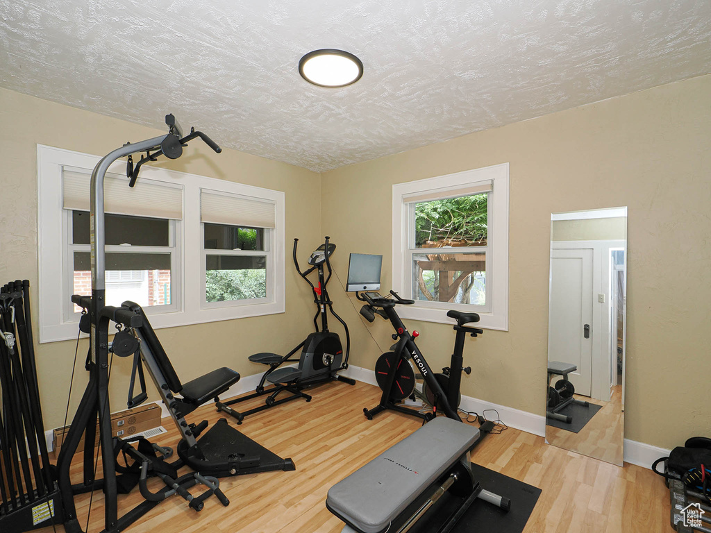 Exercise room with wood finished floors and baseboards