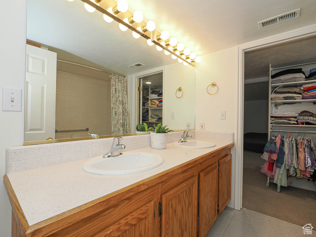 Full bath featuring double vanity and a walk in closet