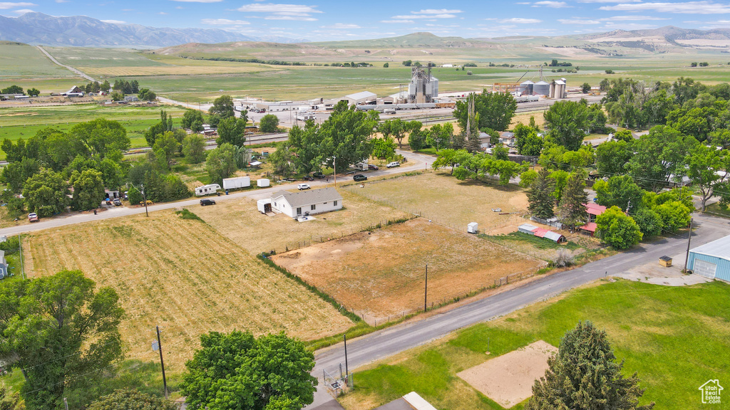Aerial view of sparsely populated area with rows of crops and mountains