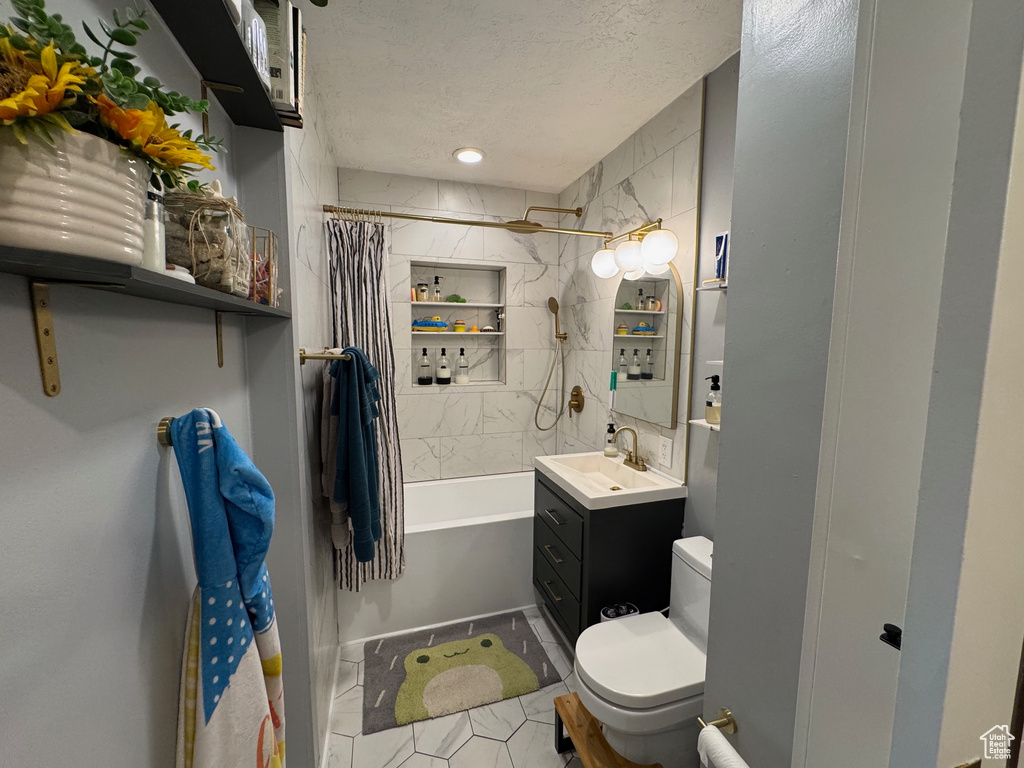 Full bath with vanity, shower / bath combo, a textured ceiling, and tile patterned flooring