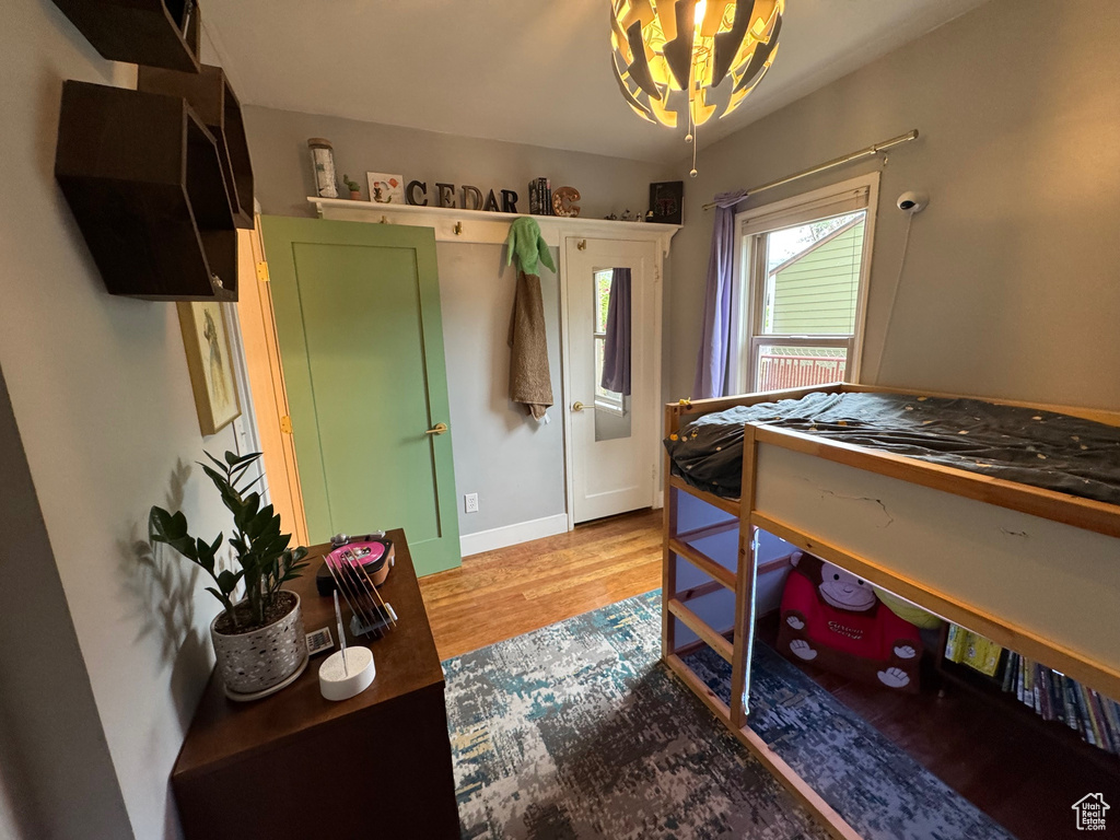 Bedroom featuring a chandelier and wood finished floors