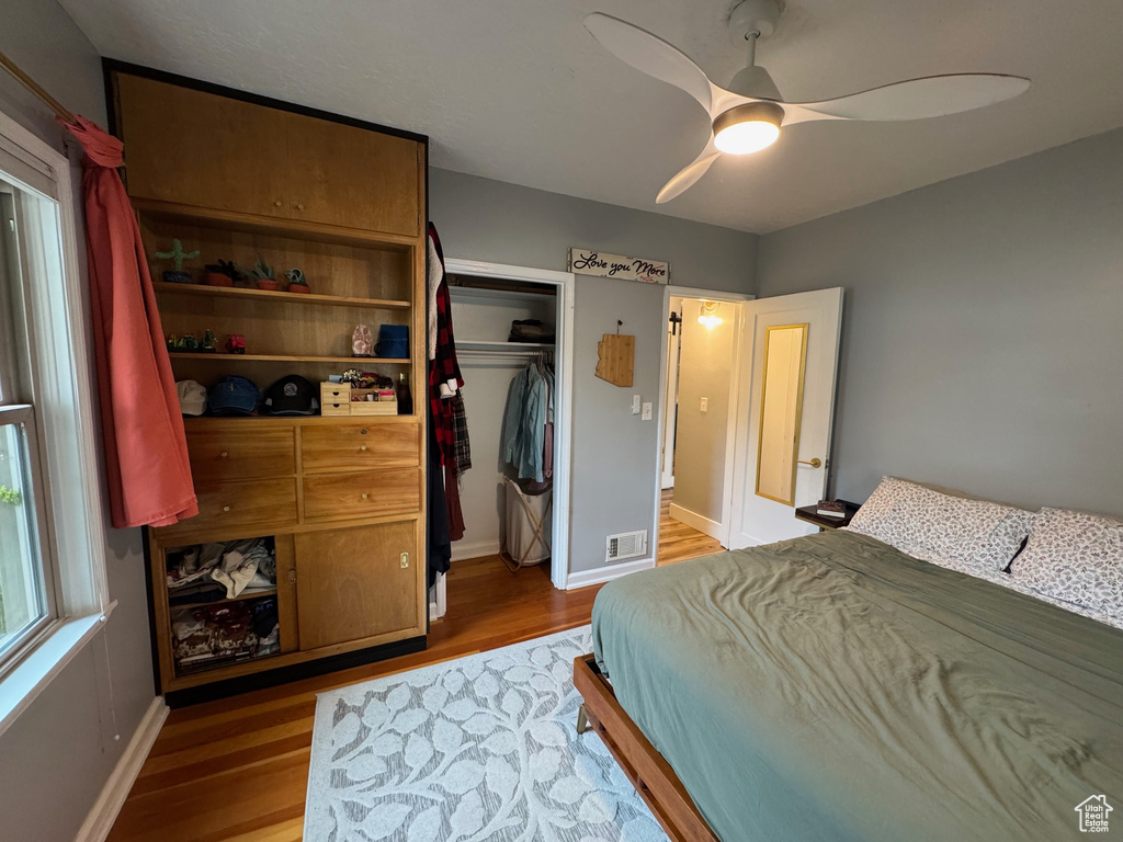Bedroom featuring wood finished floors, a closet, and a ceiling fan