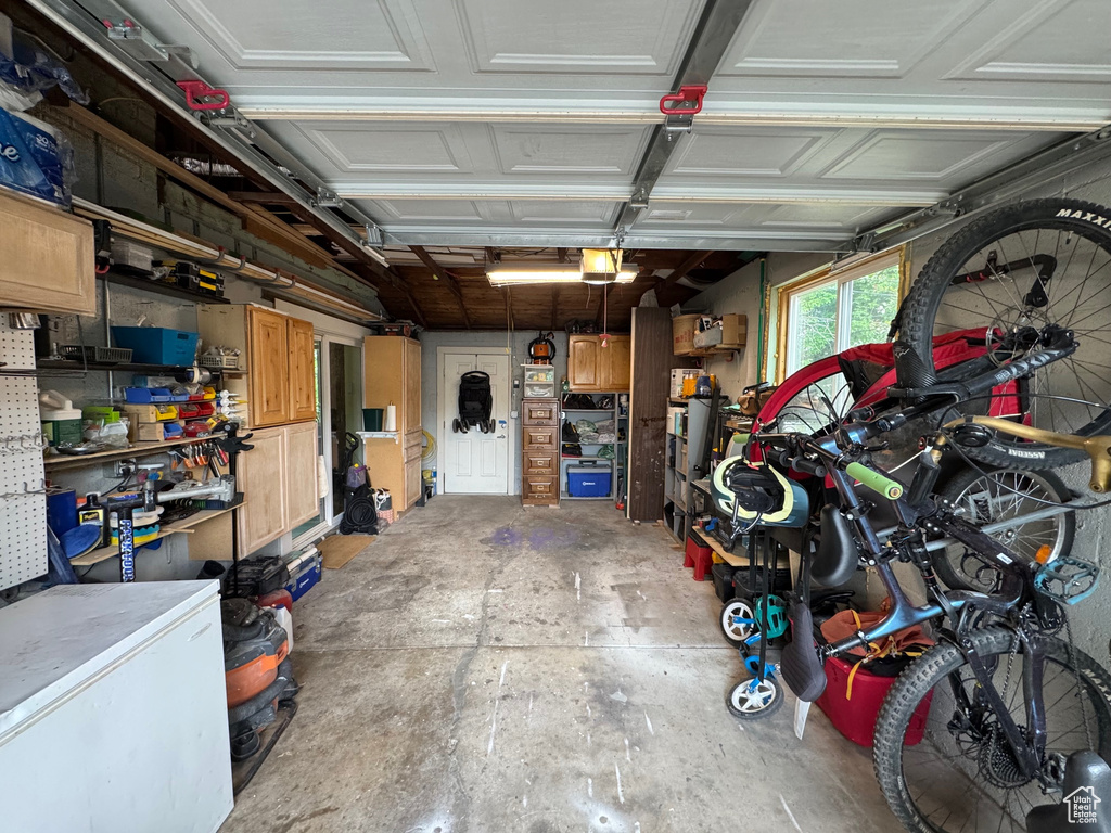 Garage featuring a garage door opener and fridge