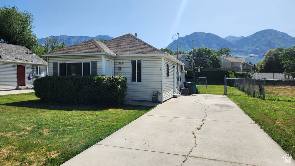 View of side of home featuring a mountain view and concrete driveway