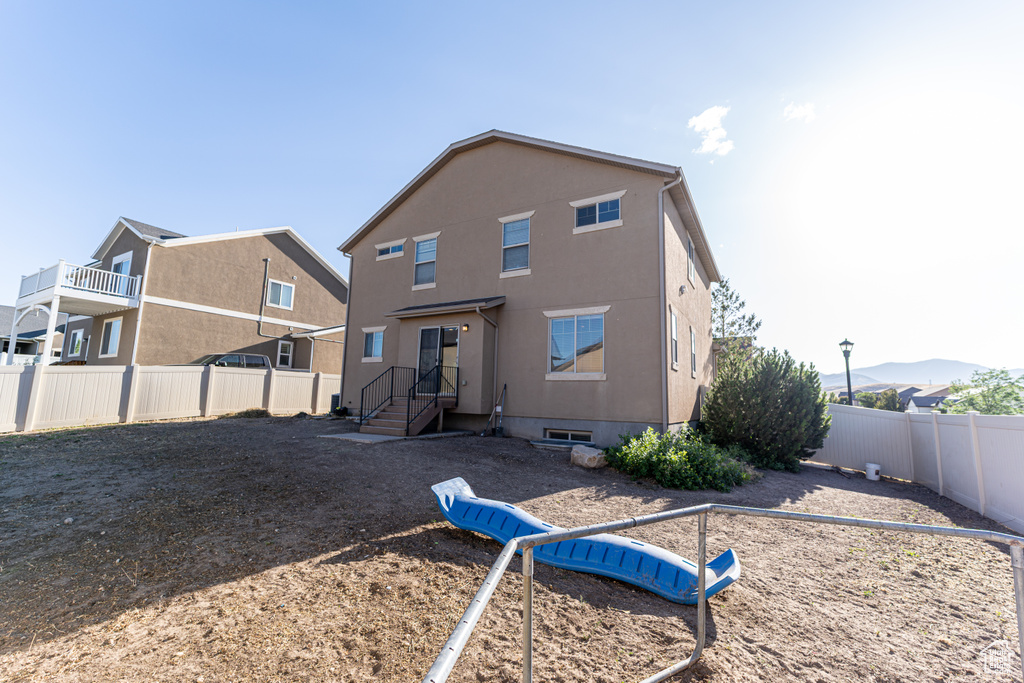 Rear view of property with a fenced backyard and stucco siding