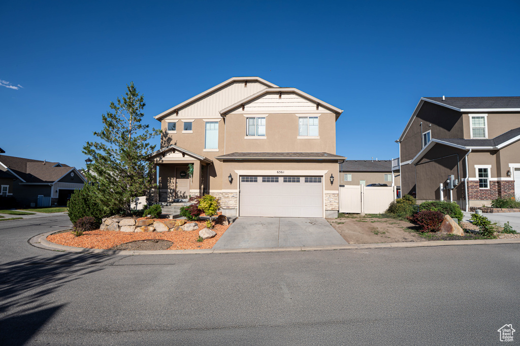 Craftsman house with concrete driveway, stucco siding, an attached garage, and stone siding