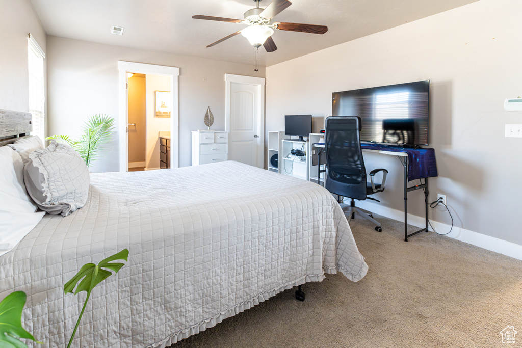 Carpeted bedroom featuring ceiling fan and connected bathroom
