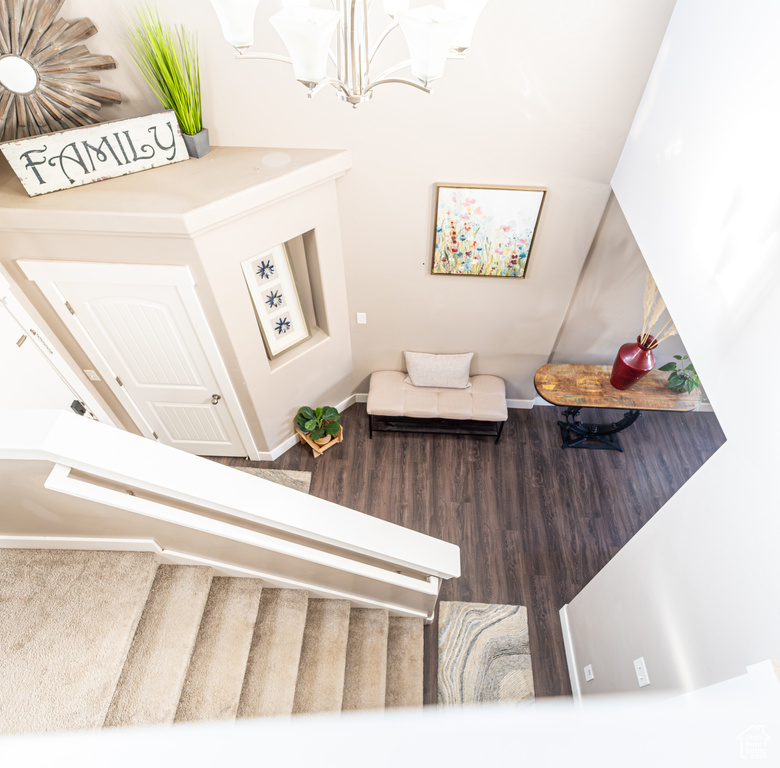 Stairway with a chandelier and wood finished floors