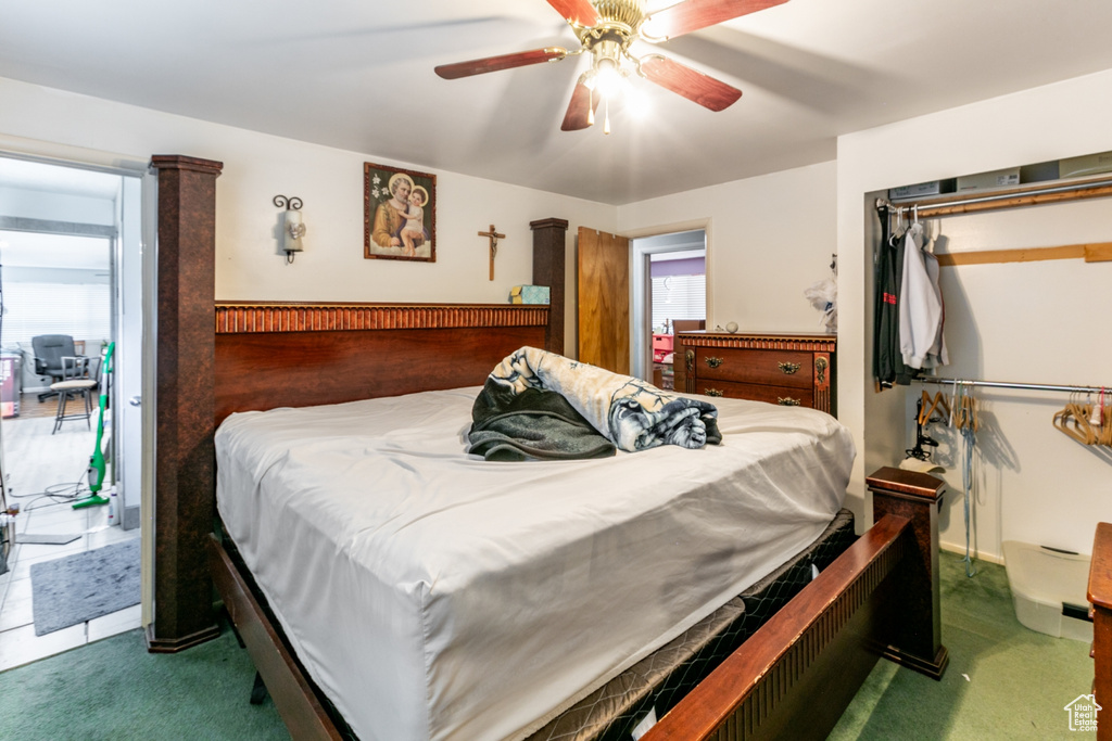 Carpeted bedroom featuring a closet, a ceiling fan, access to outside, and multiple windows