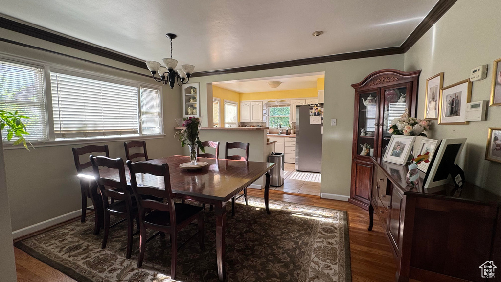 Dining space featuring a chandelier, crown molding, and wood finished floors