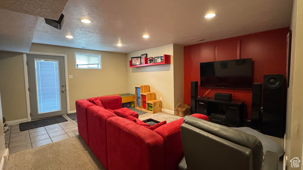 Living room with recessed lighting, light tile patterned floors, and a textured ceiling
