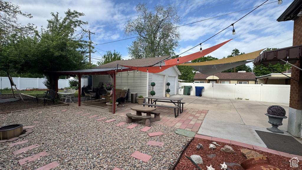 Fenced backyard with a patio area and an outbuilding