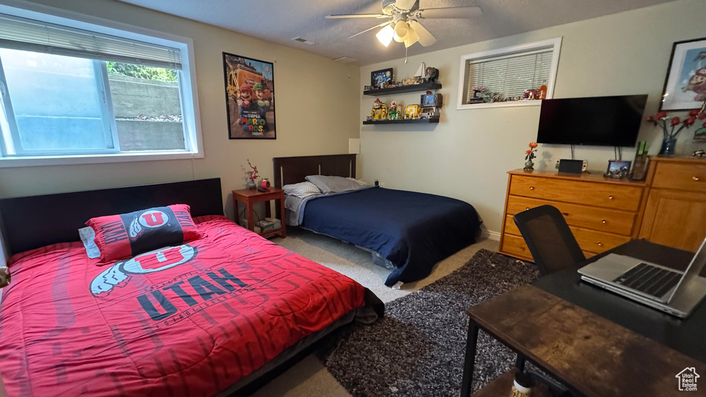 Carpeted bedroom featuring a ceiling fan