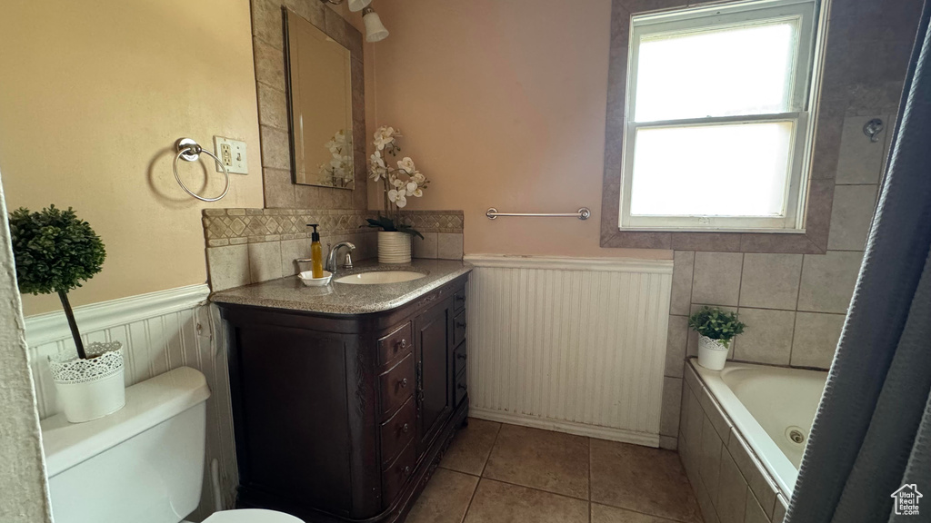 Full bathroom with a wainscoted wall, vanity, and tile patterned floors