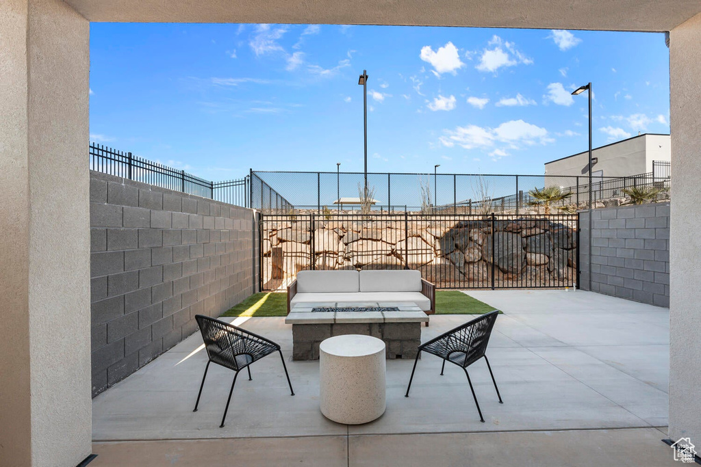 Fenced backyard with a patio area and an outdoor living space with a fire pit