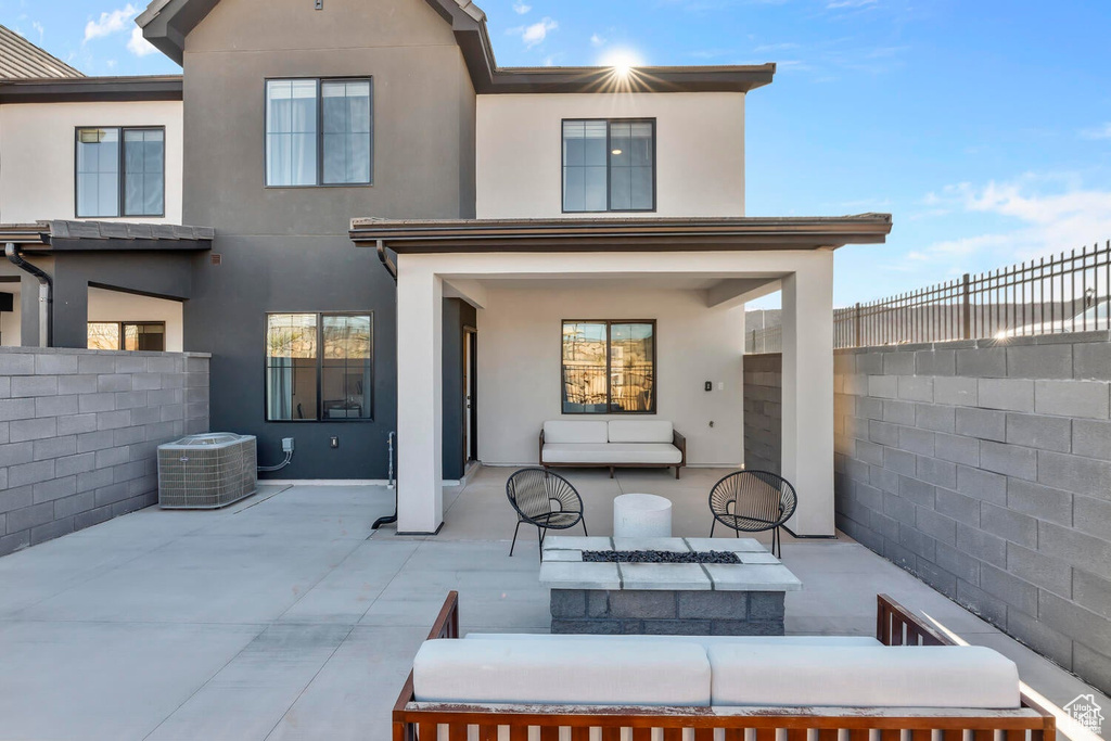 Rear view of property with stucco siding, a patio area, and a fenced backyard