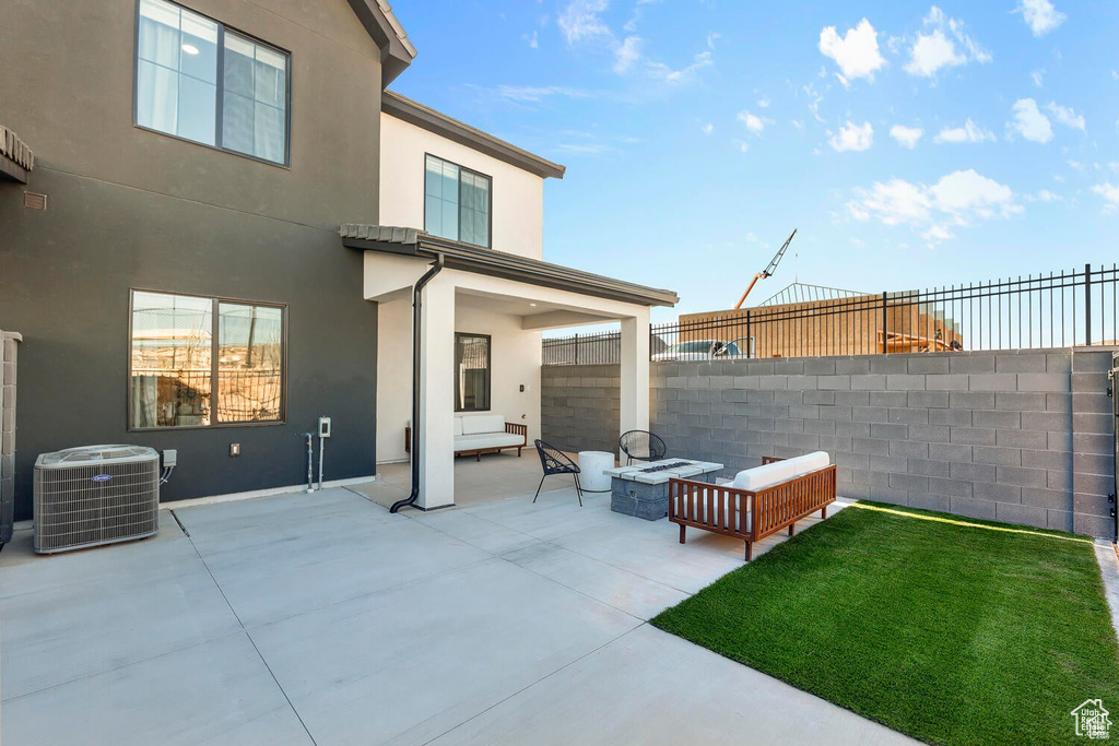 Fenced backyard featuring a patio and an outdoor living space with a fire pit