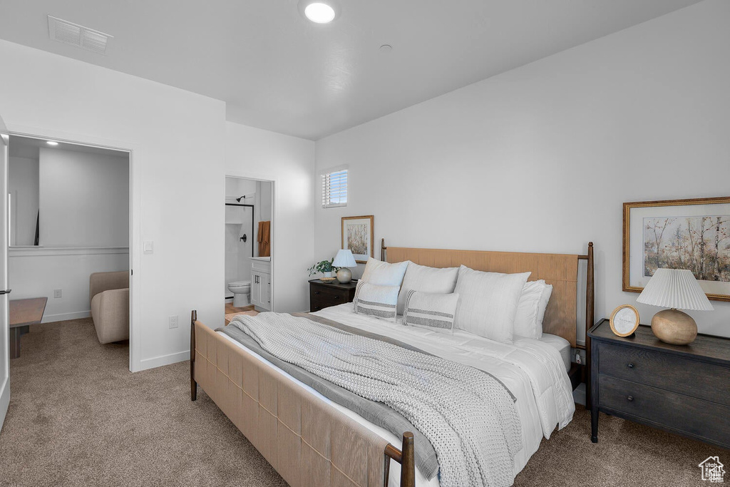 Bedroom with light carpet and ensuite bathroom