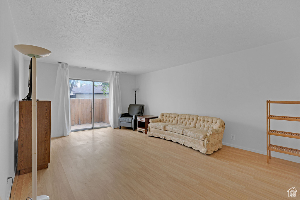 Living area with light wood finished floors and a textured ceiling