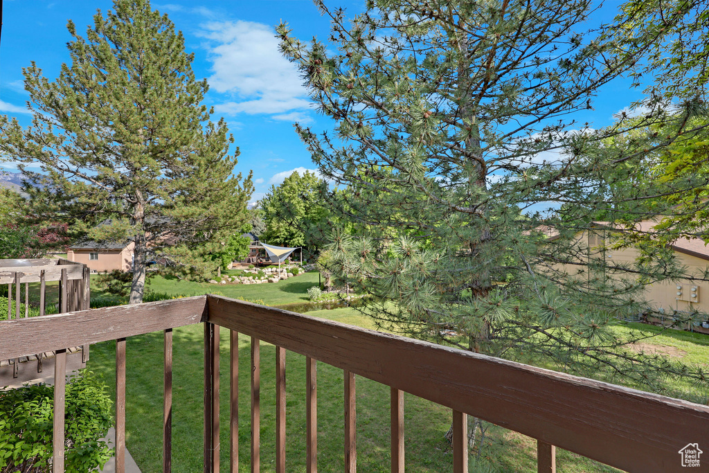 View of grassy yard featuring a balcony