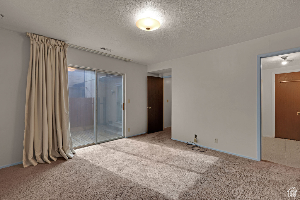 Spare room with a textured ceiling and carpet flooring