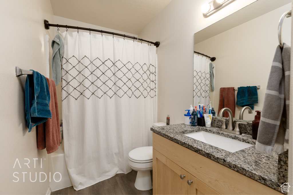 Full bath featuring vanity, wood finished floors, and shower / tub combo