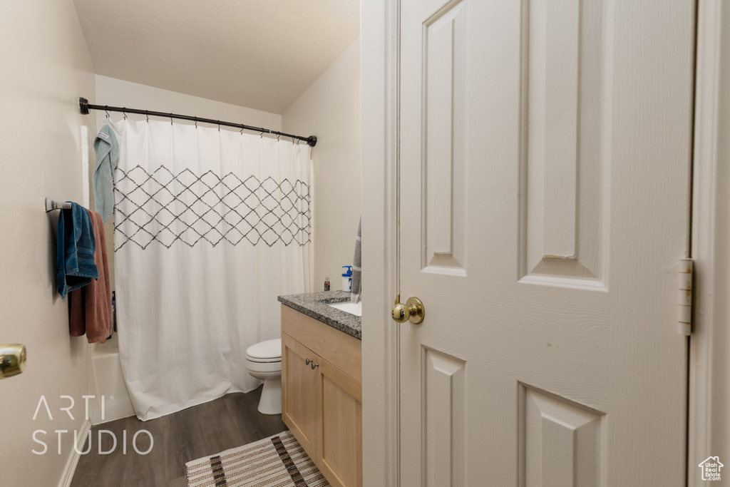 Full bathroom with wood finished floors, vanity, and shower / bathtub combination with curtain