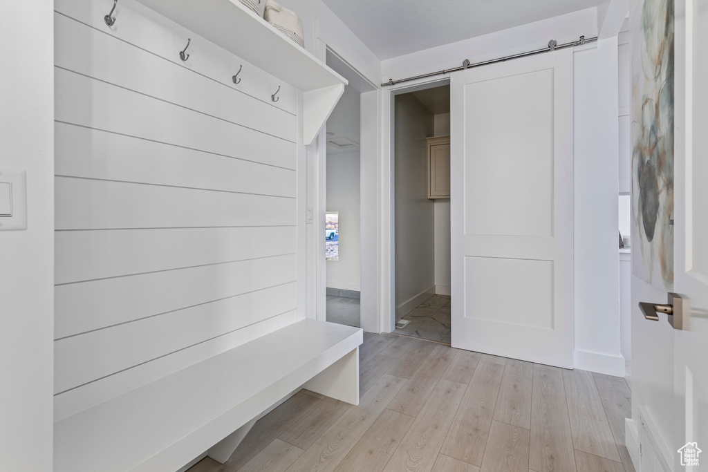 Mudroom featuring light wood-style flooring and a barn door