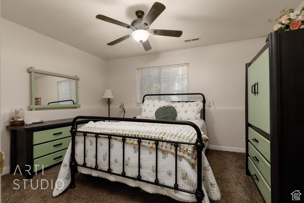 Bedroom featuring dark carpet and a ceiling fan