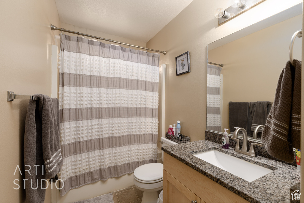 Full bath featuring vanity, tile patterned flooring, and shower / bath combo