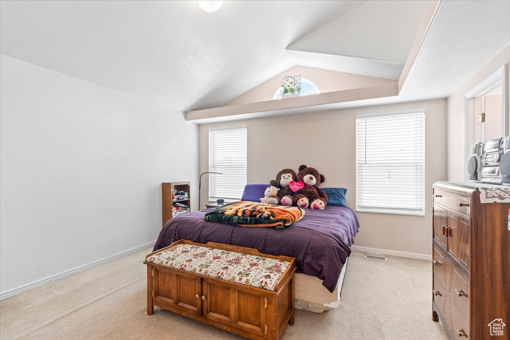 Bedroom featuring light carpet and vaulted ceiling