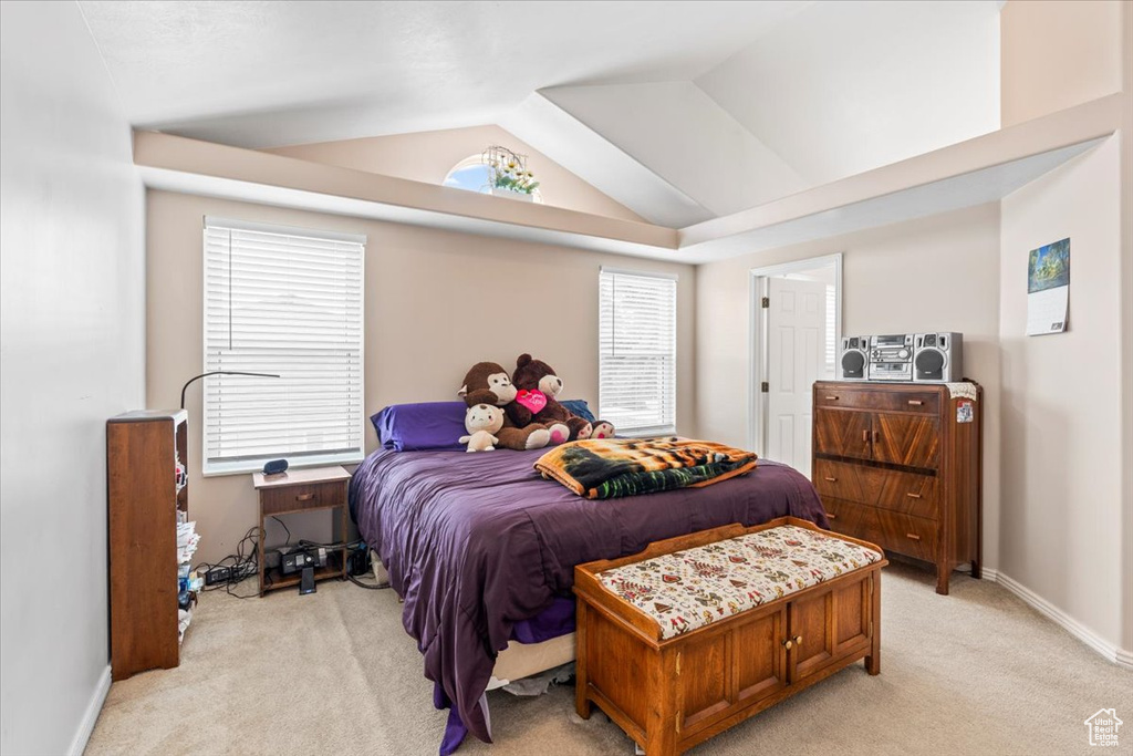 Bedroom featuring light colored carpet and lofted ceiling
