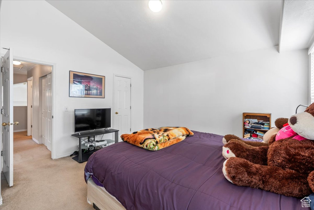 Bedroom featuring vaulted ceiling and light carpet
