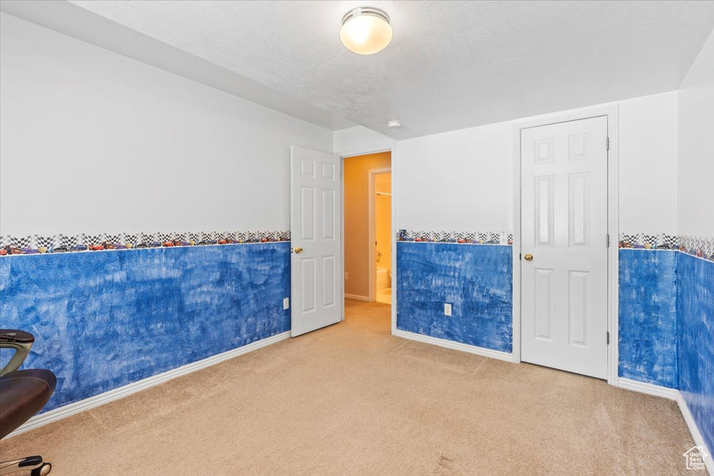 Carpeted spare room featuring baseboards