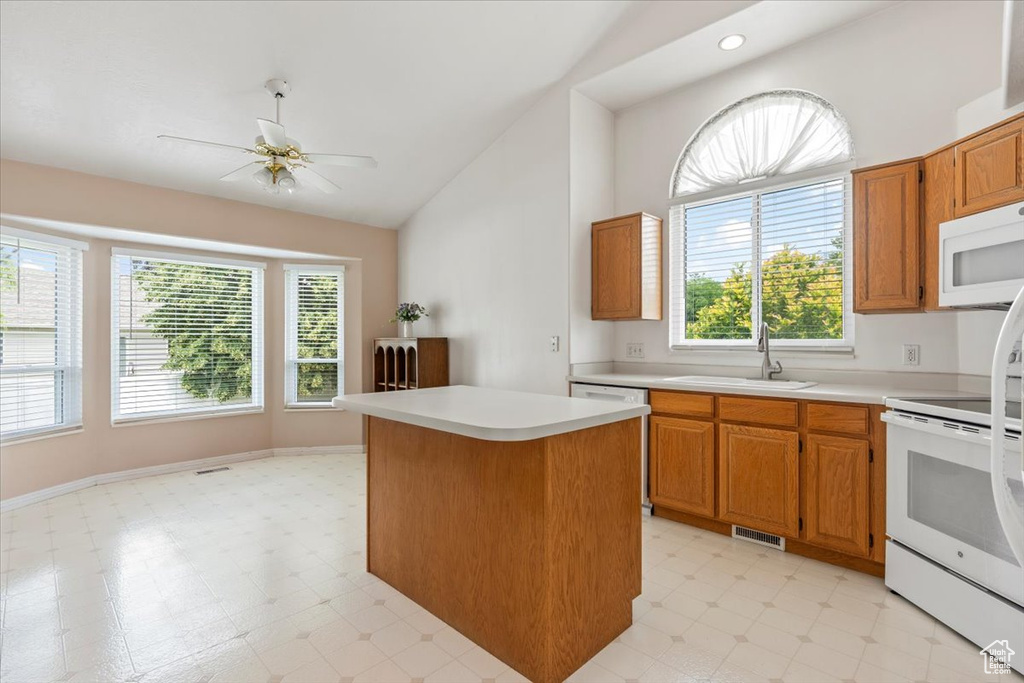 Kitchen featuring white appliances, light countertops, ceiling fan, high vaulted ceiling, and light floors