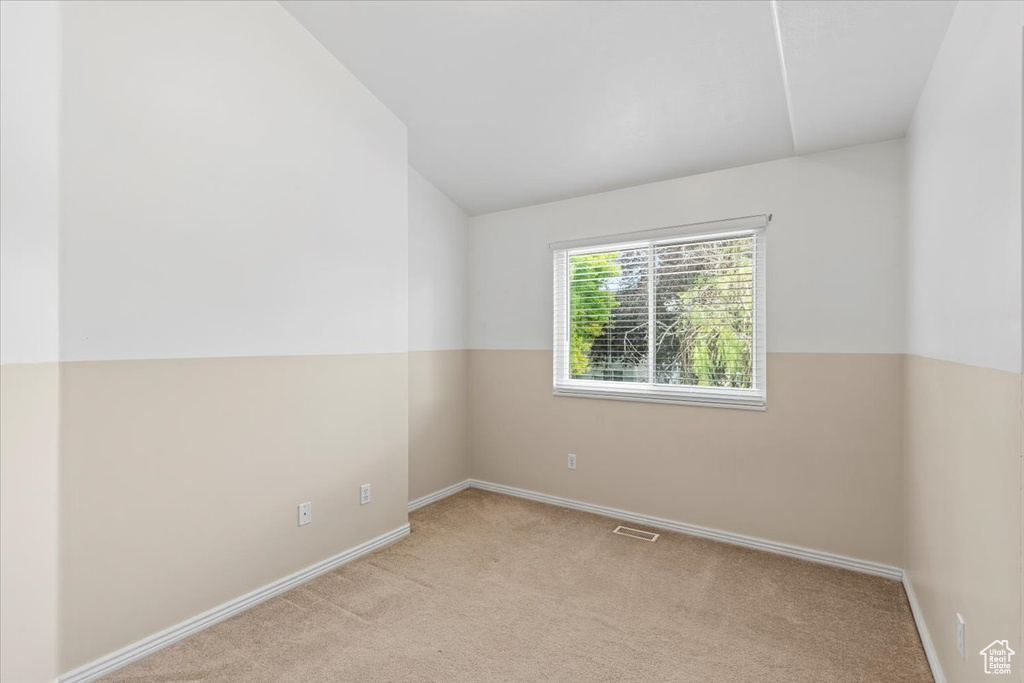 Unfurnished room with lofted ceiling and carpet floors