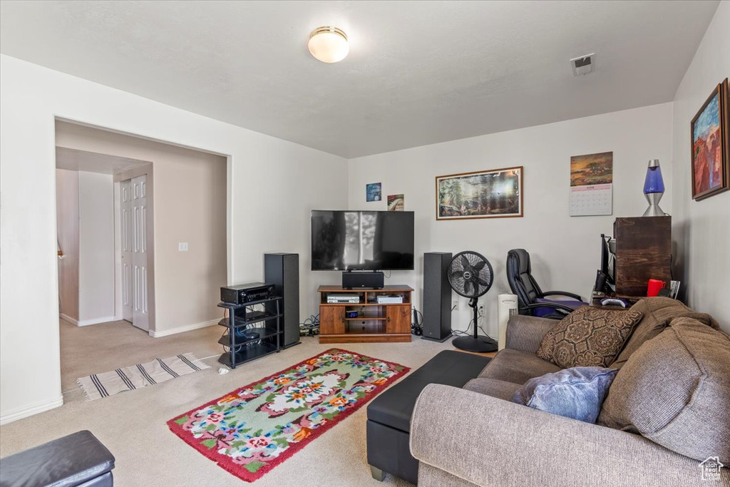 Living area featuring light colored carpet and baseboards