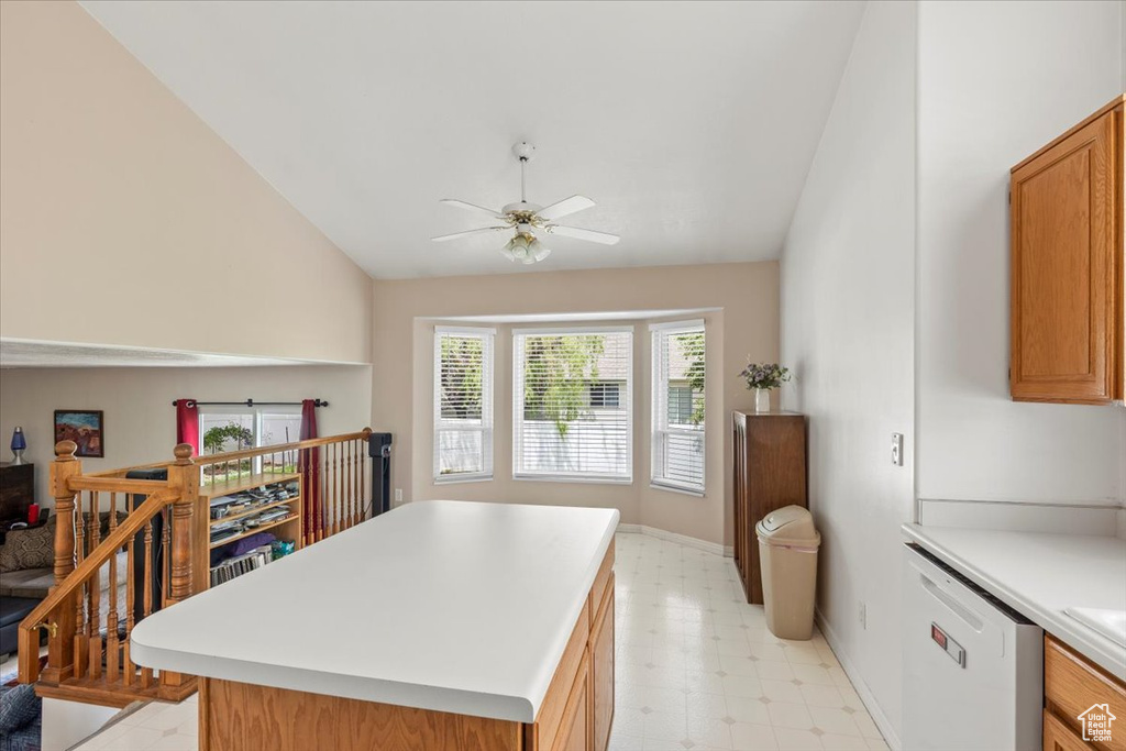 Kitchen with white dishwasher, lofted ceiling, light floors, a ceiling fan, and light countertops
