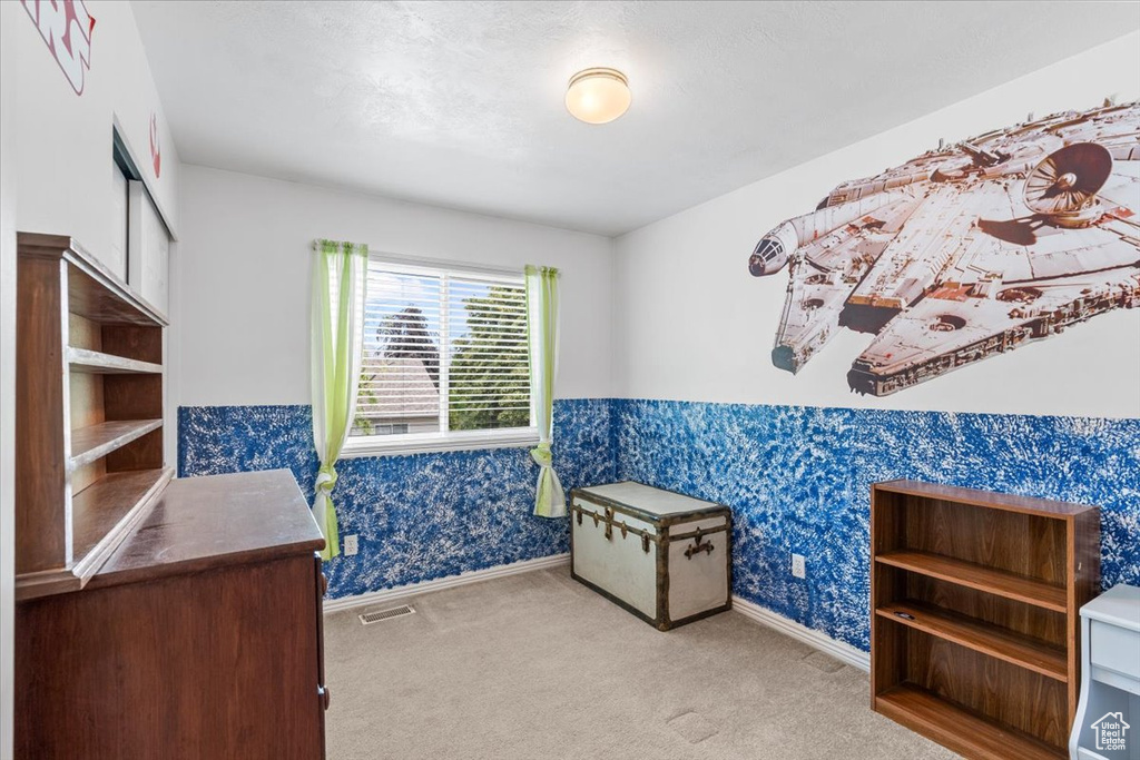 Bedroom featuring wallpapered walls and carpet floors
