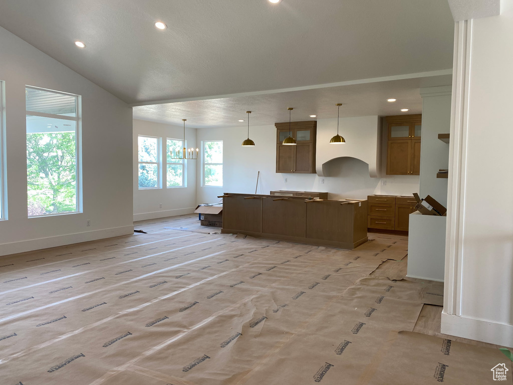 Kitchen with a center island, recessed lighting, pendant lighting, open floor plan, and brown cabinetry