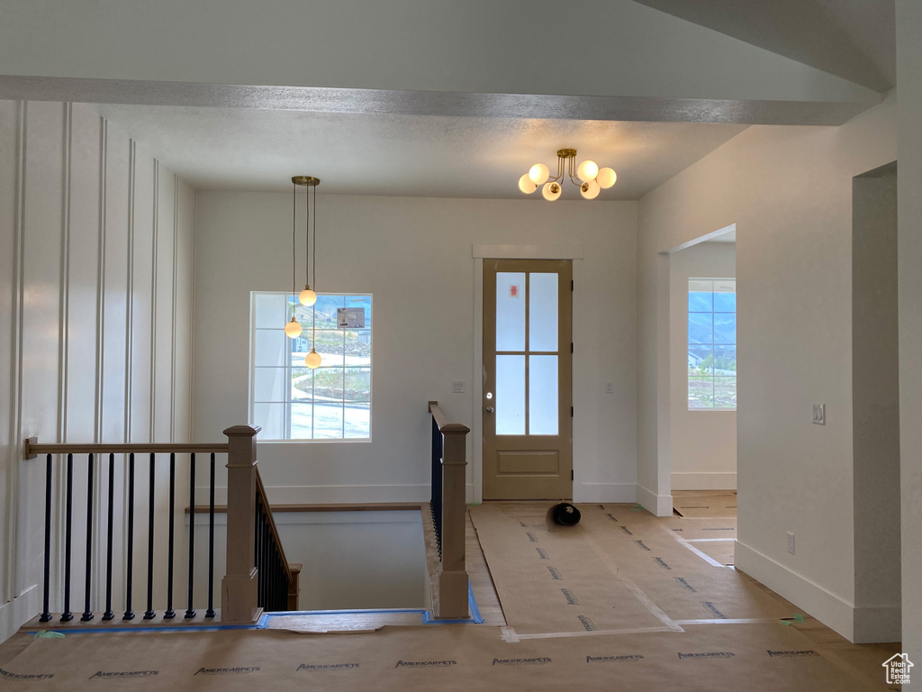 Foyer with baseboards and a chandelier