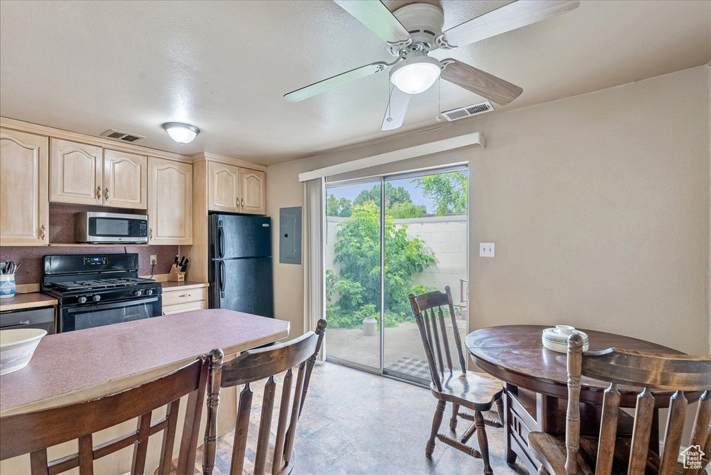 Kitchen with black appliances, light brown cabinets, electric panel, a ceiling fan, and light countertops