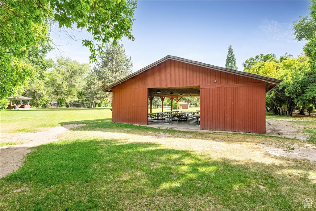 View of property's community with a lawn, an outdoor structure, and a pole building